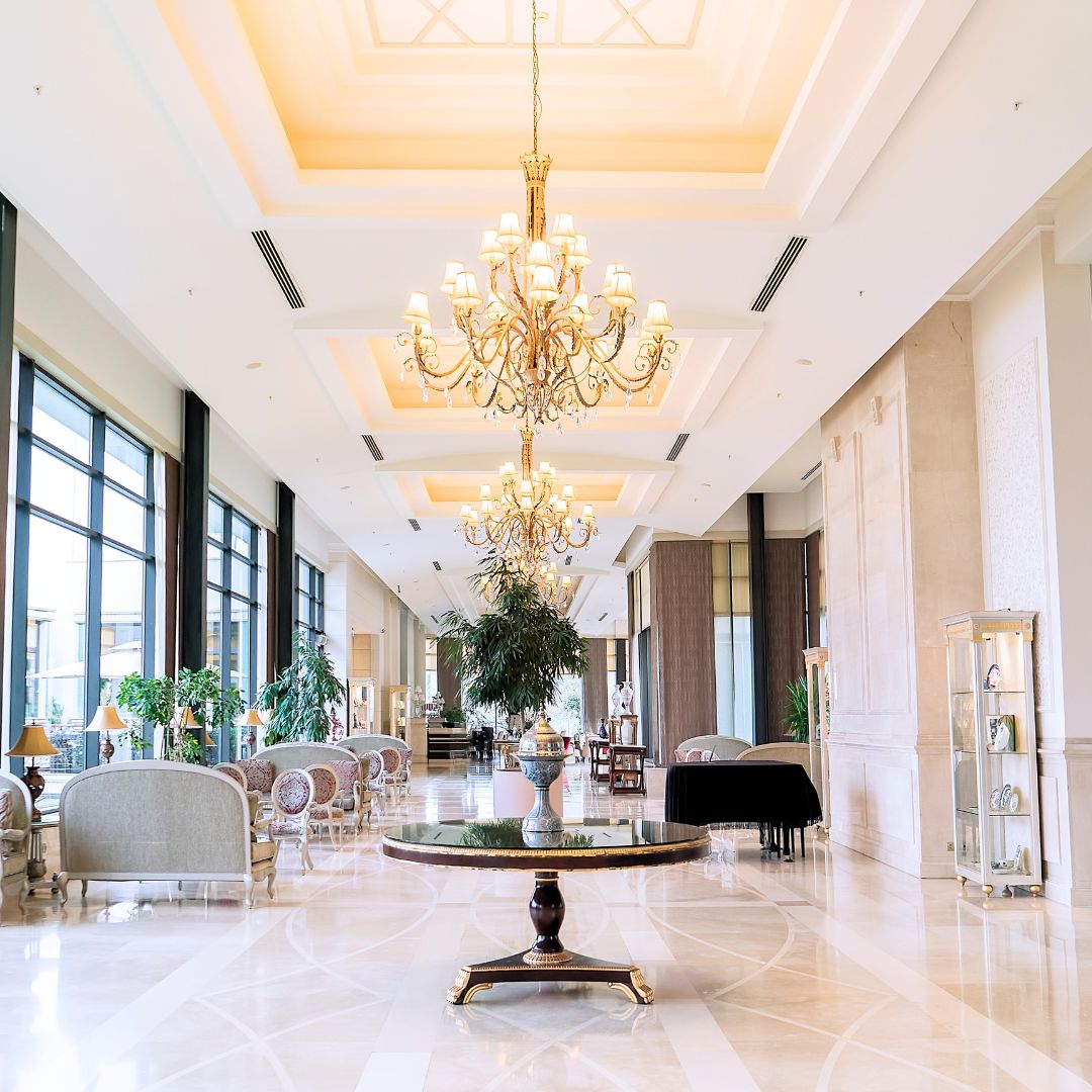 Grand luxury hotel lobby with crystal chandeliers and marble flooring, evoking the standards of five-star hospitality groups.
